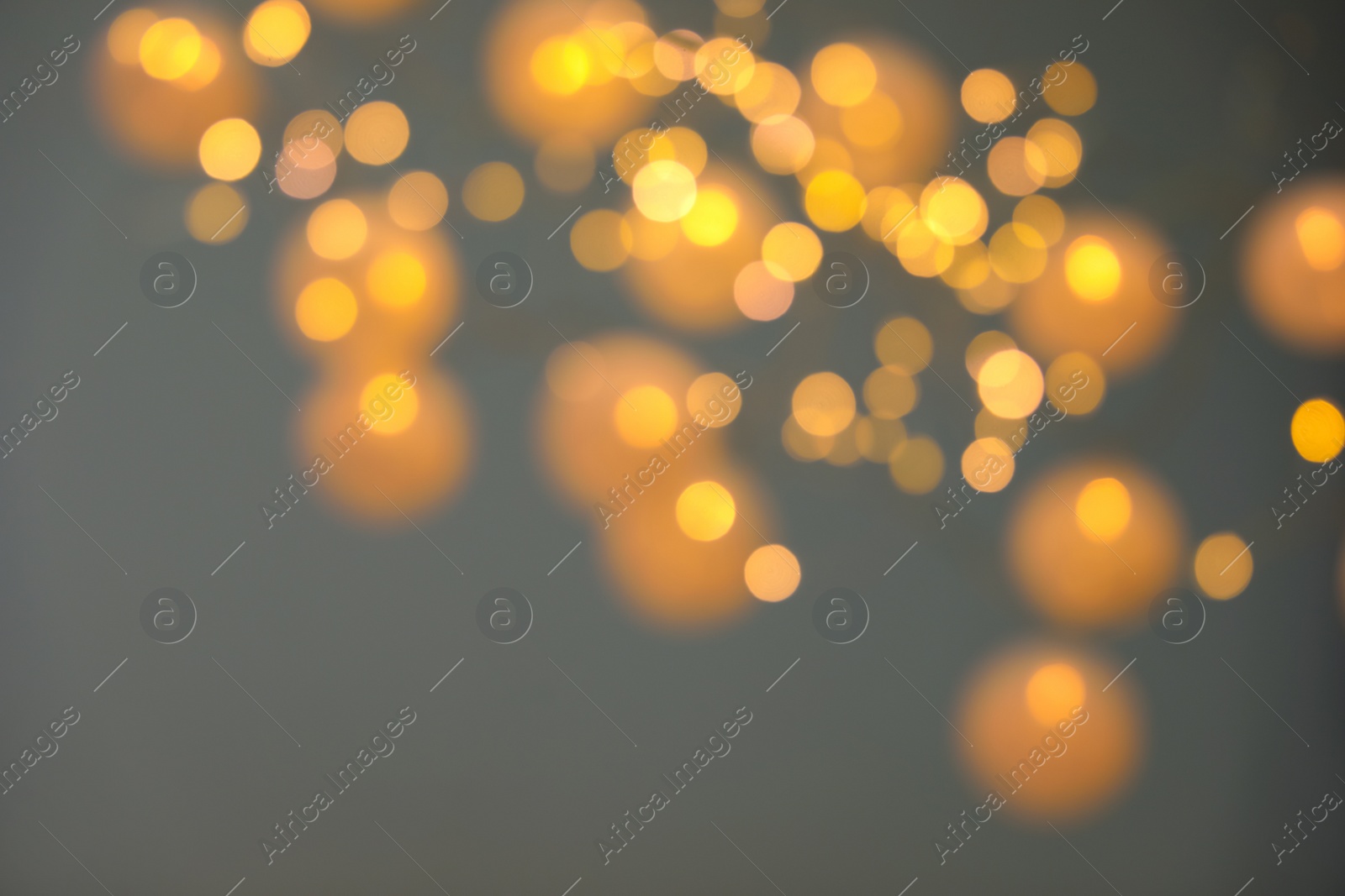 Photo of Blurred view of gold lights on dark background. Bokeh effect