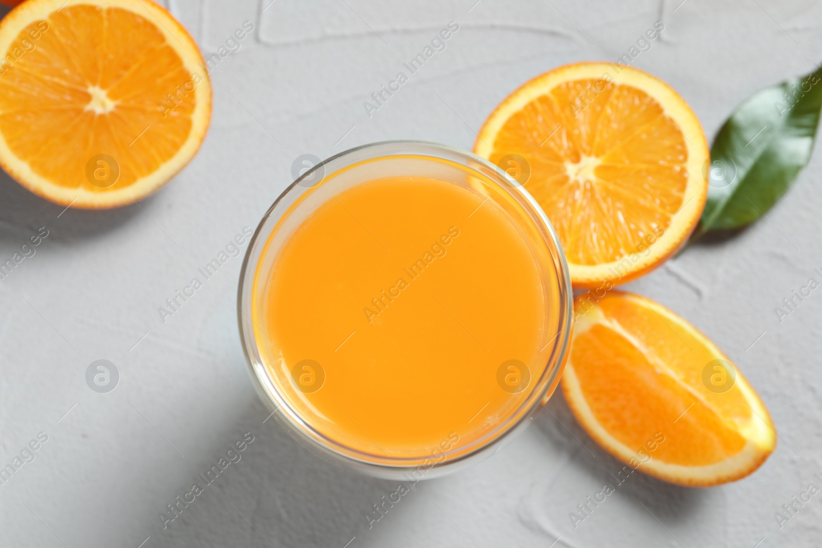 Photo of Glass of orange juice and fresh fruits on table, top view