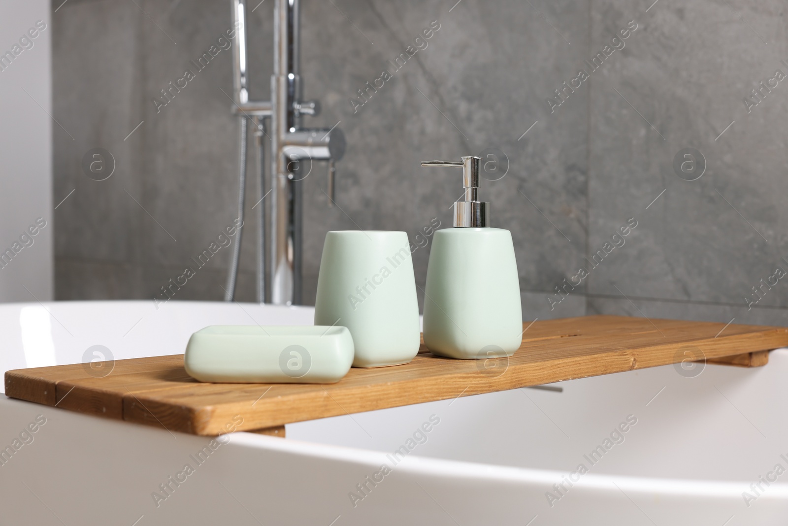 Photo of Set of bath accessories on tub in bathroom