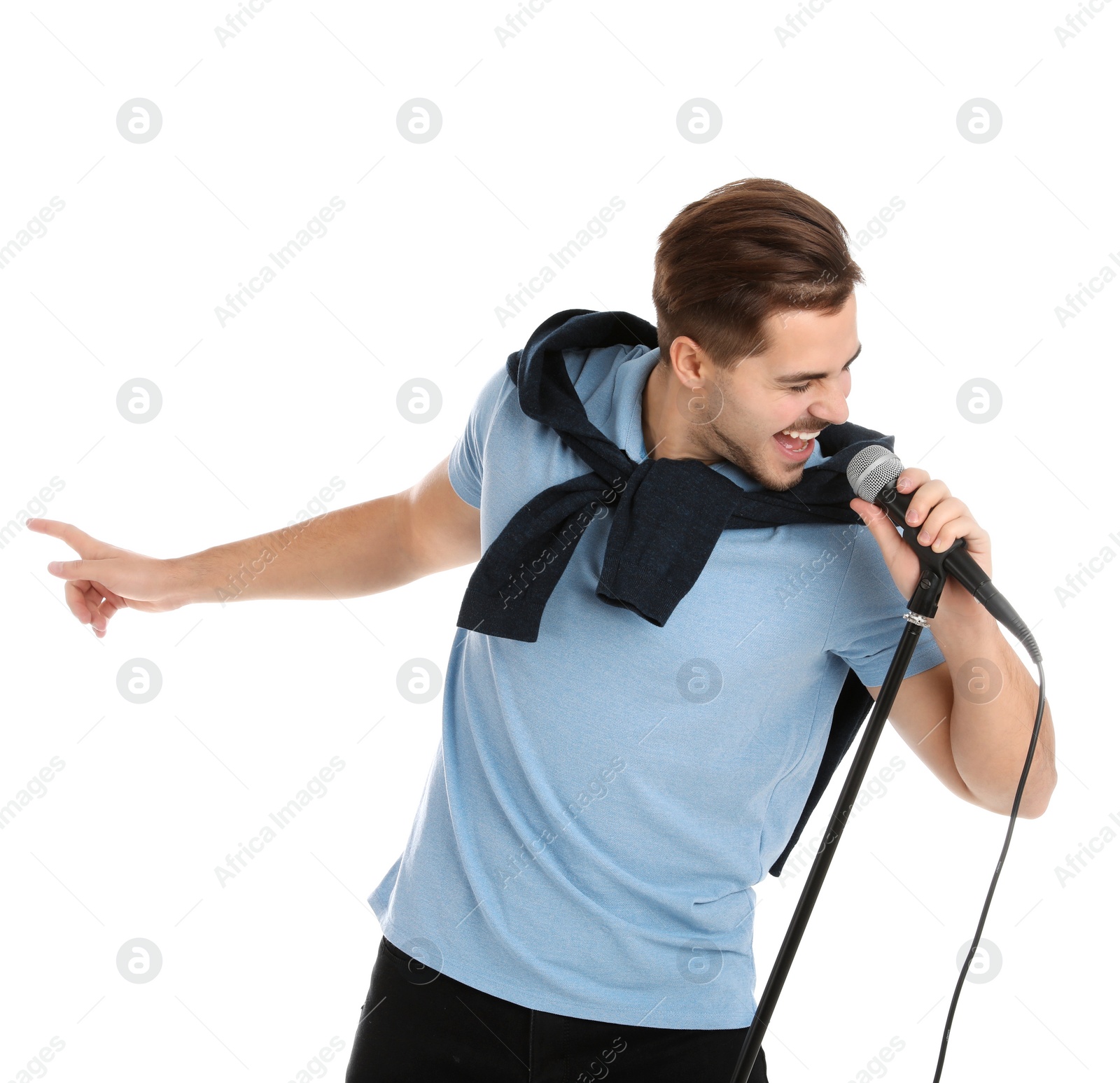 Photo of Young handsome man in casual clothes singing with microphone on white background