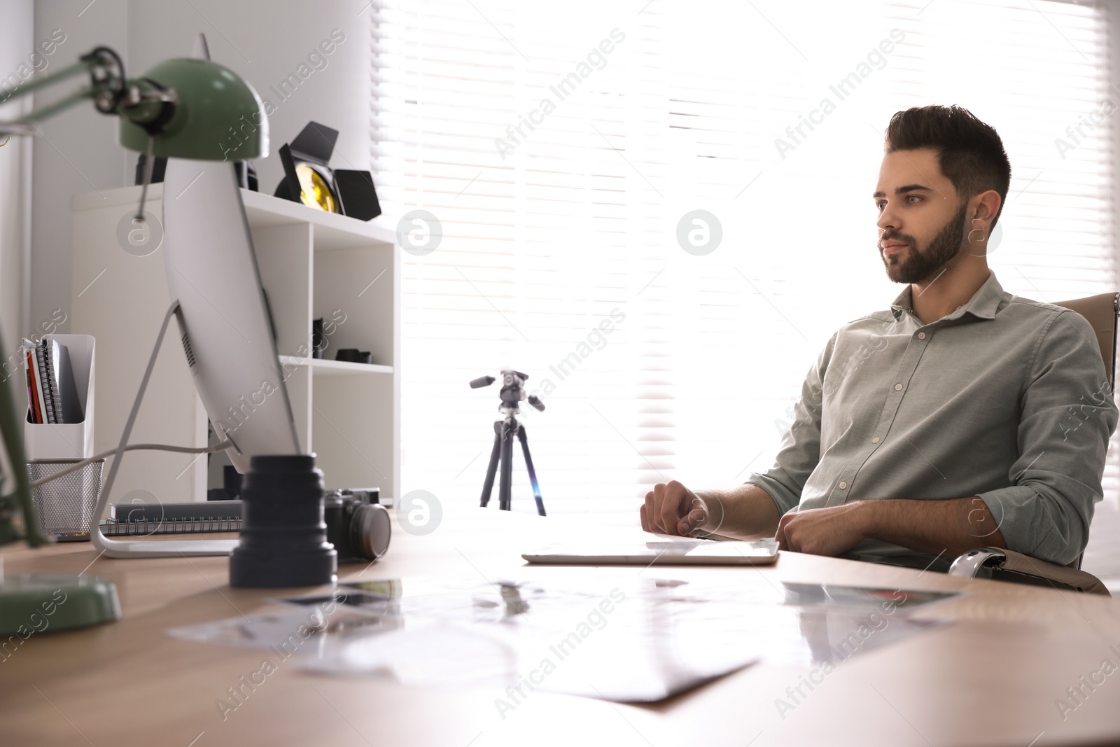 Photo of Professional photographer working at table in office