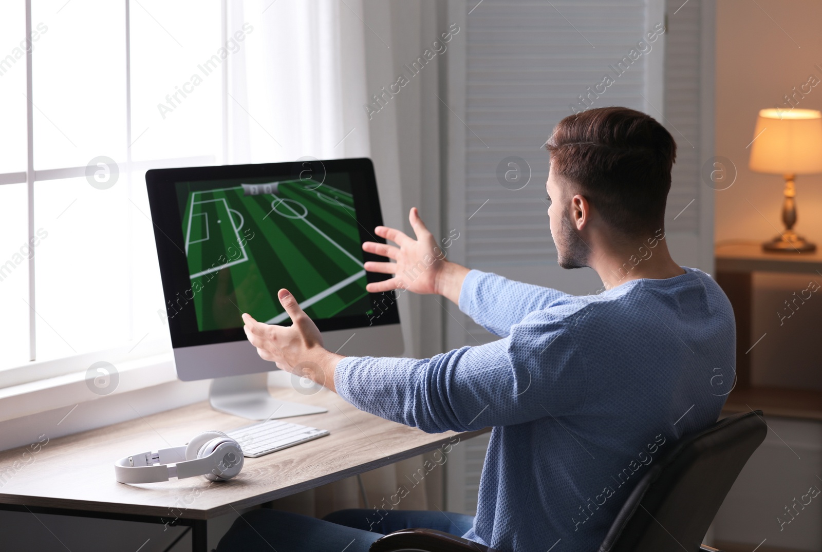 Photo of Young man playing video games at home