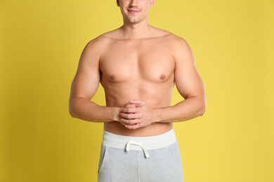 Photo of Man with sexy body on yellow background, closeup
