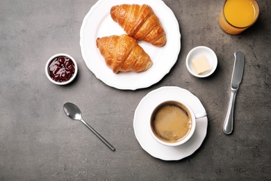 Flat lay composition with cup of coffee and croissants on grey background