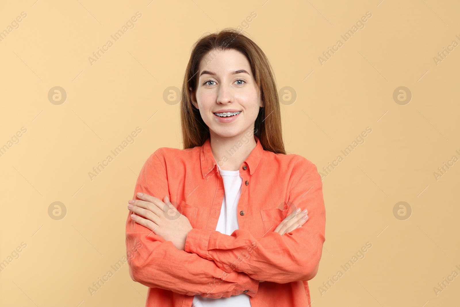 Photo of Portrait of smiling woman with dental braces on beige background