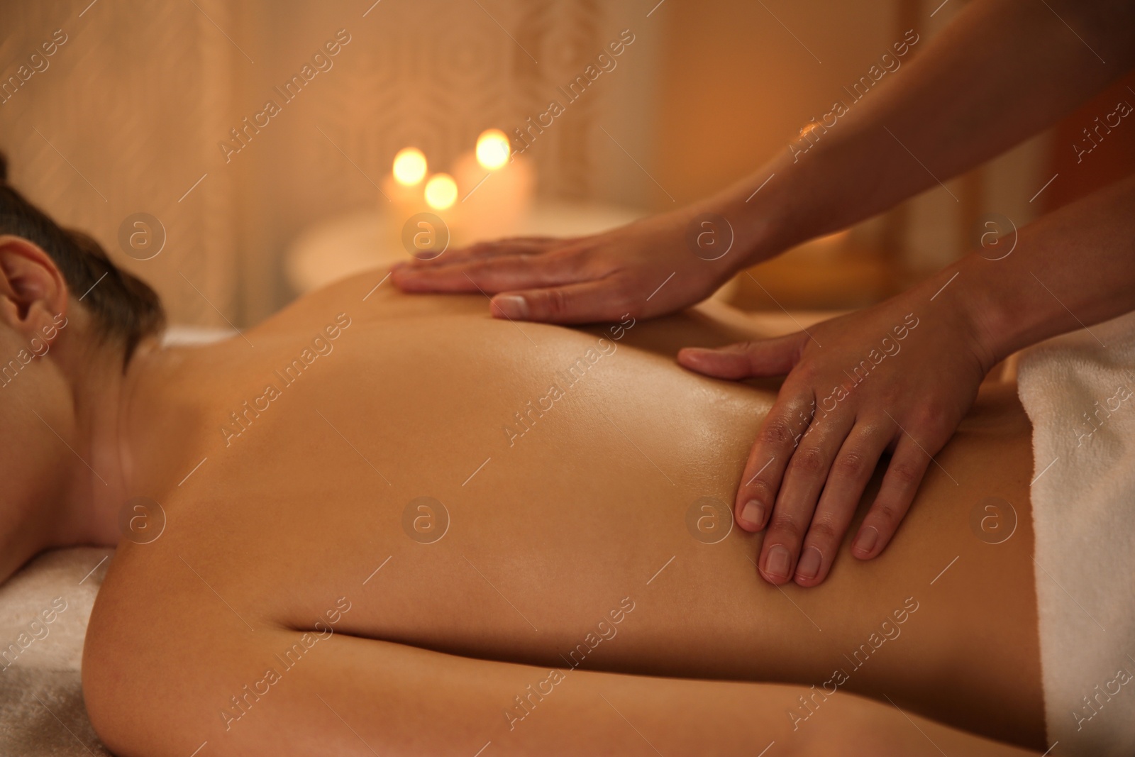 Photo of Young woman receiving back massage in spa salon, closeup