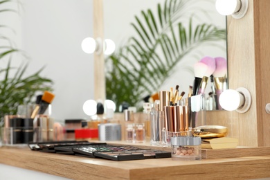 Photo of Set of luxury makeup products and accessories on dressing table with mirror. Space for text