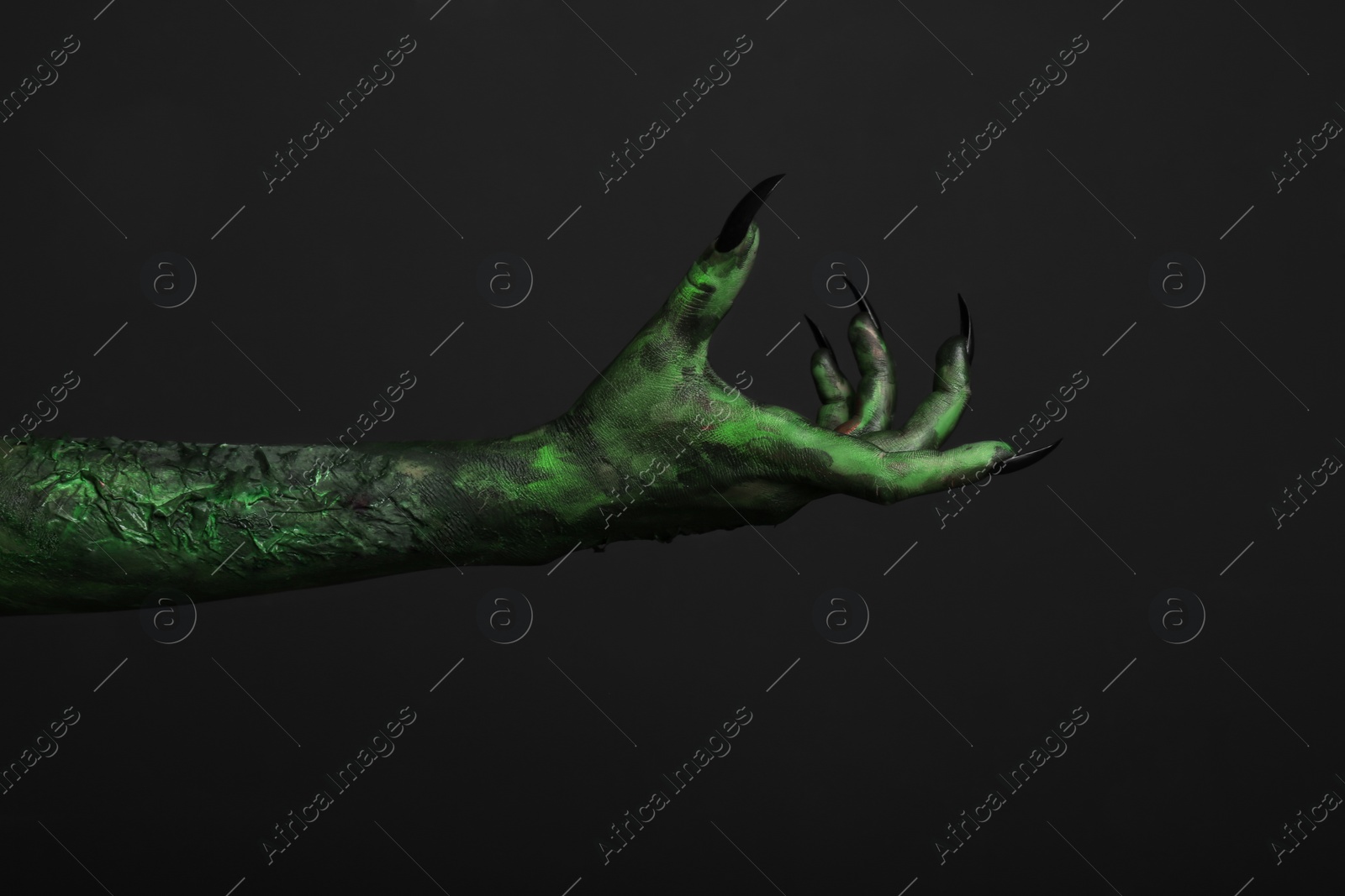 Photo of Scary monster on black background, closeup of hand. Halloween character