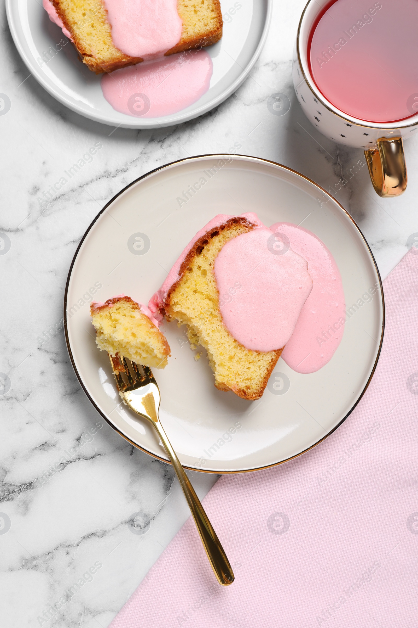 Photo of Delicious cake with pink glaze served on white marble table, flat lay