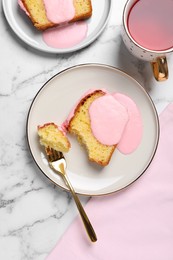 Photo of Delicious cake with pink glaze served on white marble table, flat lay