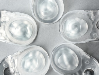Photo of Packages with contact lenses on light background