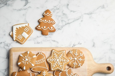 Photo of Tasty homemade Christmas cookies and board on table, top view