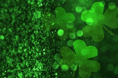 Image of St. Patrick's Day celebration. Clover leaves on dark background, bokeh effect