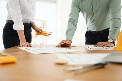 Photo of People working with construction drawings at table, closeup