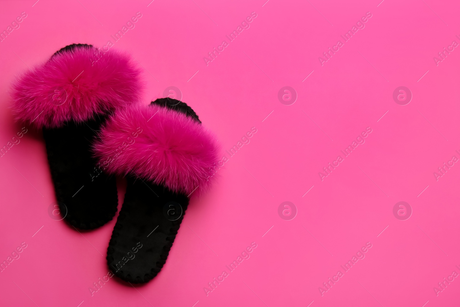 Photo of Pair of soft slippers on pink background, flat lay. Space for text