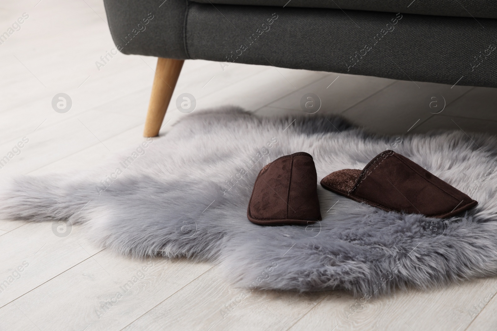 Photo of Faux fur rug with slippers on floor in room