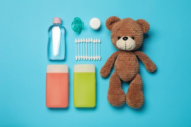 Flat lay composition with baby cosmetic products on light blue background