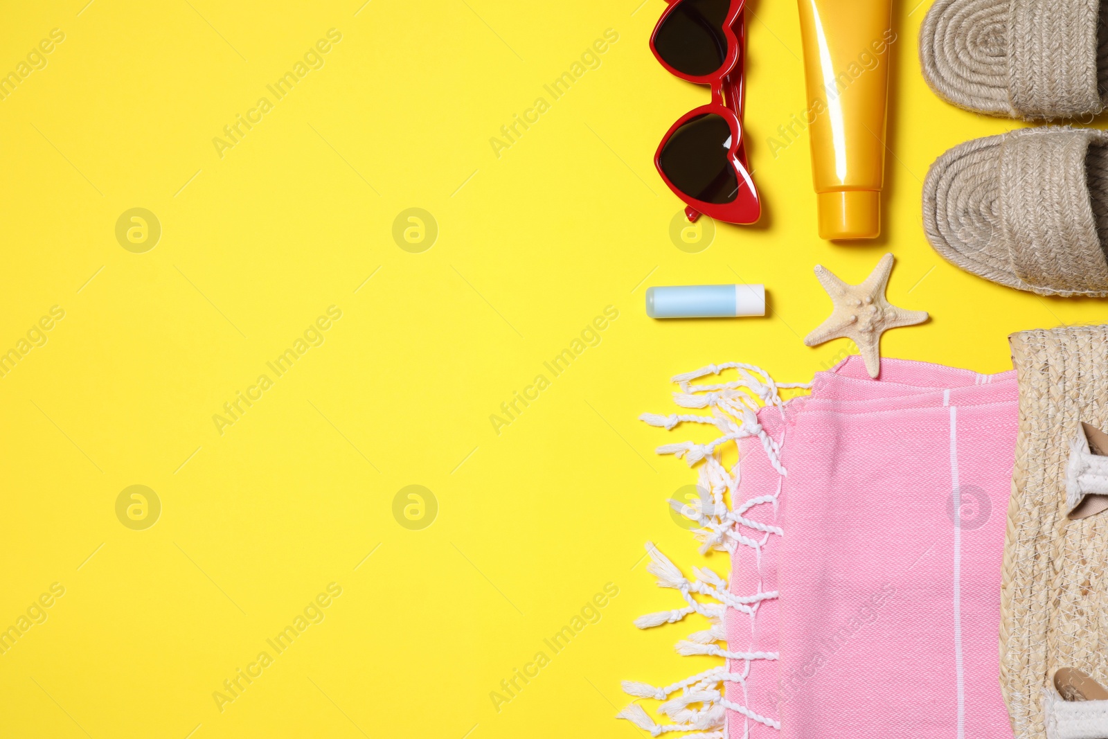 Photo of Flat lay composition with beach accessories on yellow background. Space for text