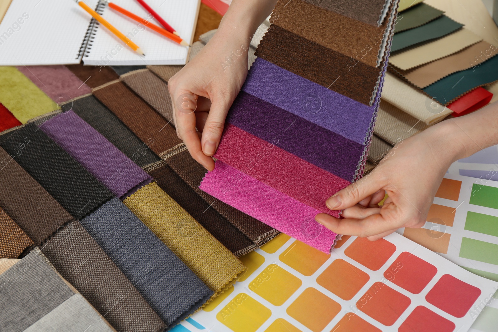 Photo of Woman choosing among colorful fabric samples, closeup