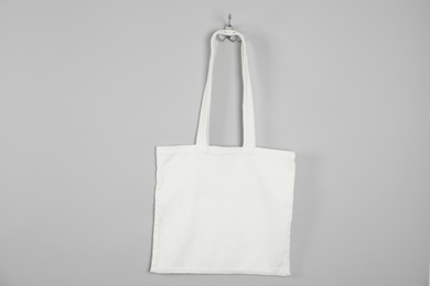 Photo of Tote bag hanging on grey wall. Mock up for design