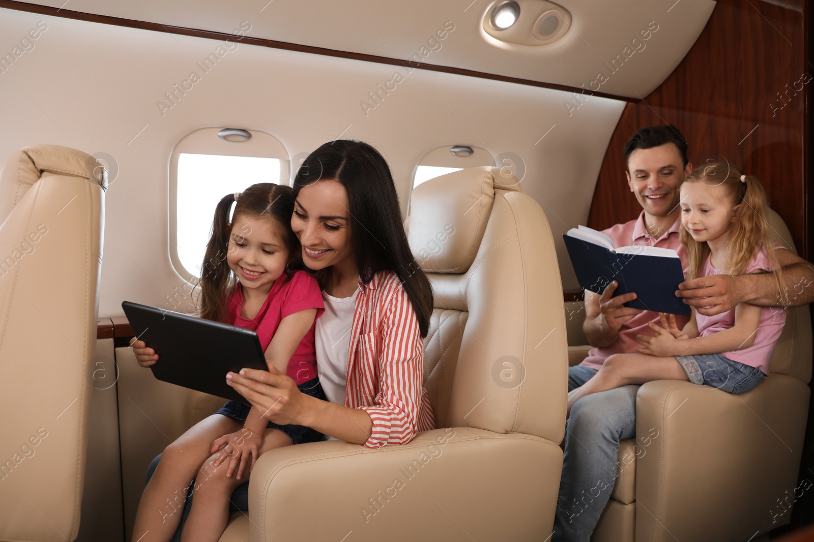 Photo of Happy family spending time together in airplane during flight