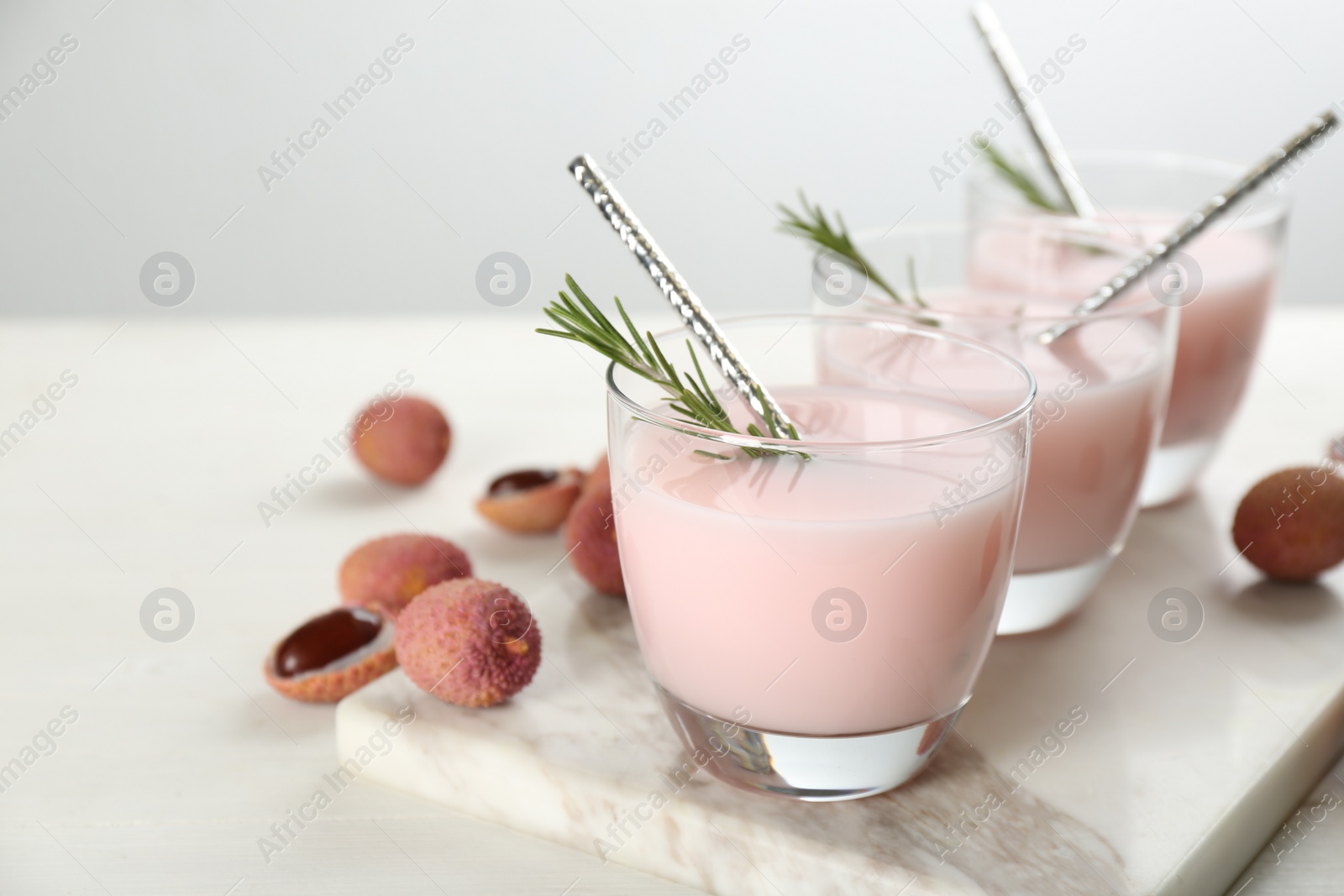 Photo of Lychee cocktail with rosemary white table, closeup