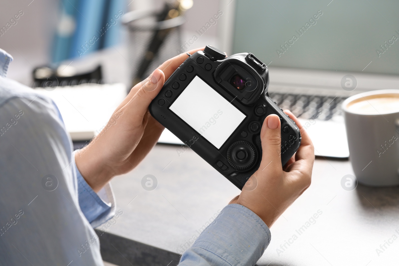 Photo of Journalist with camera at table in office, closeup