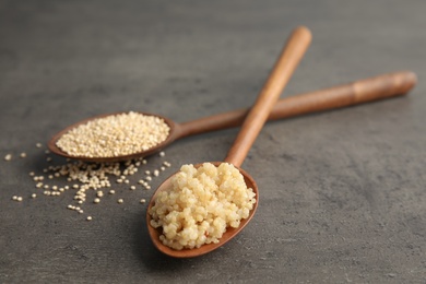 Photo of Spoons with raw and cooked quinoa on table