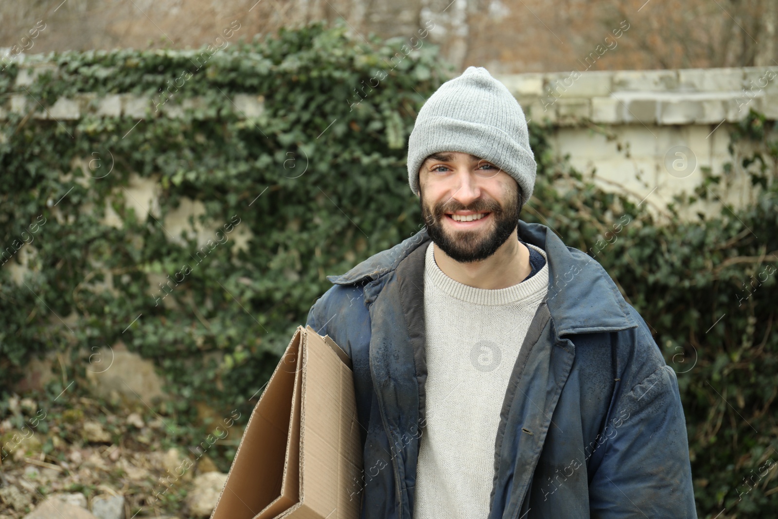 Photo of Poor homeless man with cardboard on street