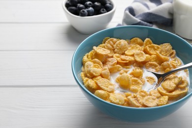 Photo of Bowl of tasty corn flakes served on white wooden table. Space for text