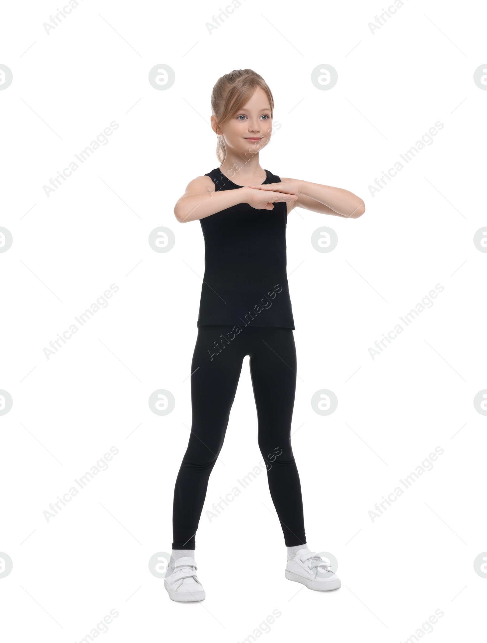 Photo of Little girl doing morning exercise on white background