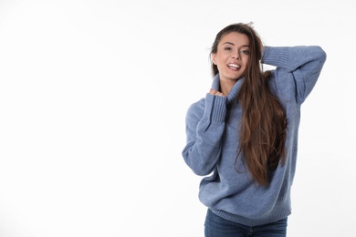 Young woman in stylish blue sweater on white background