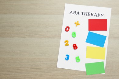 Photo of Phrase ABA Therapy and different colors with numbers on white wooden table, top view. Space for text