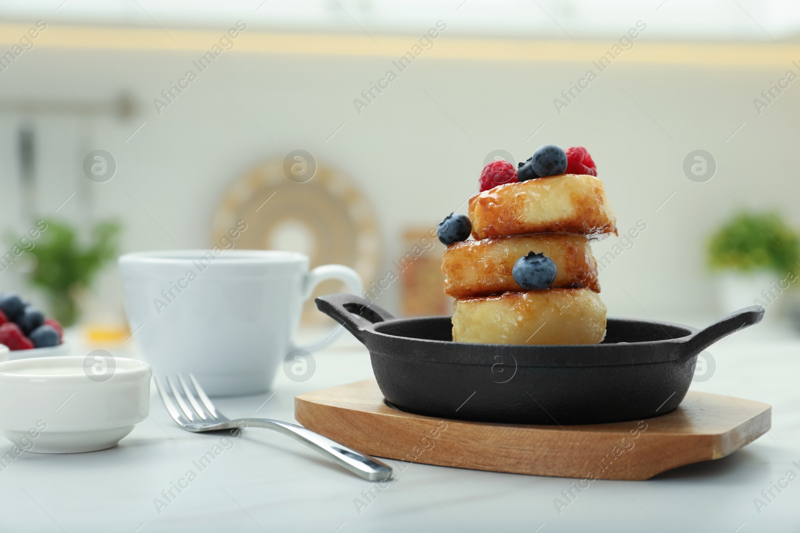 Photo of Delicious cottage cheese pancakes with fresh berries and honey served on white table. Space for text