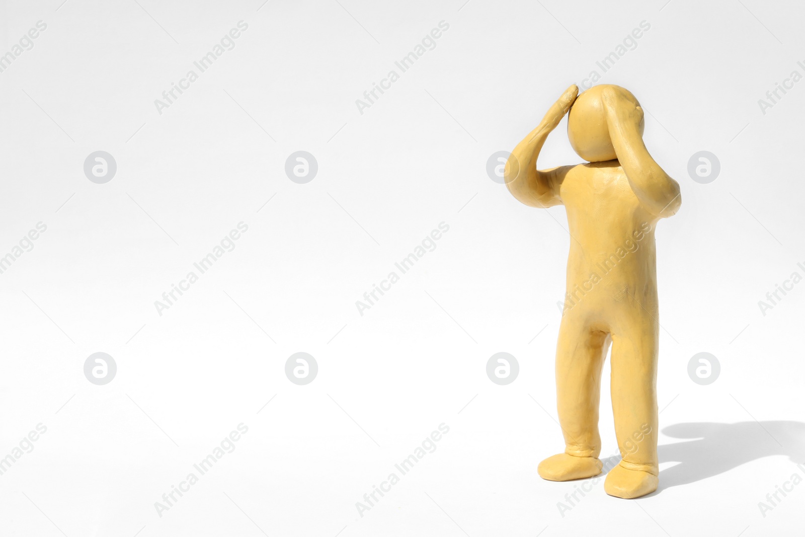 Photo of Plasticine figure of troubled human on white background. Space for text