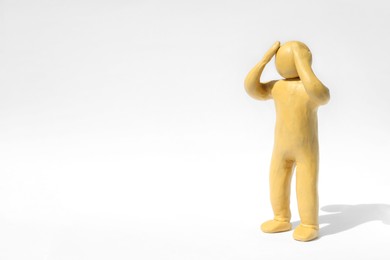 Photo of Plasticine figure of troubled human on white background. Space for text