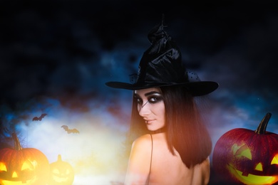 Image of Young girl dressed as witch and spooky pumpkin heads at night. Halloween fantasy