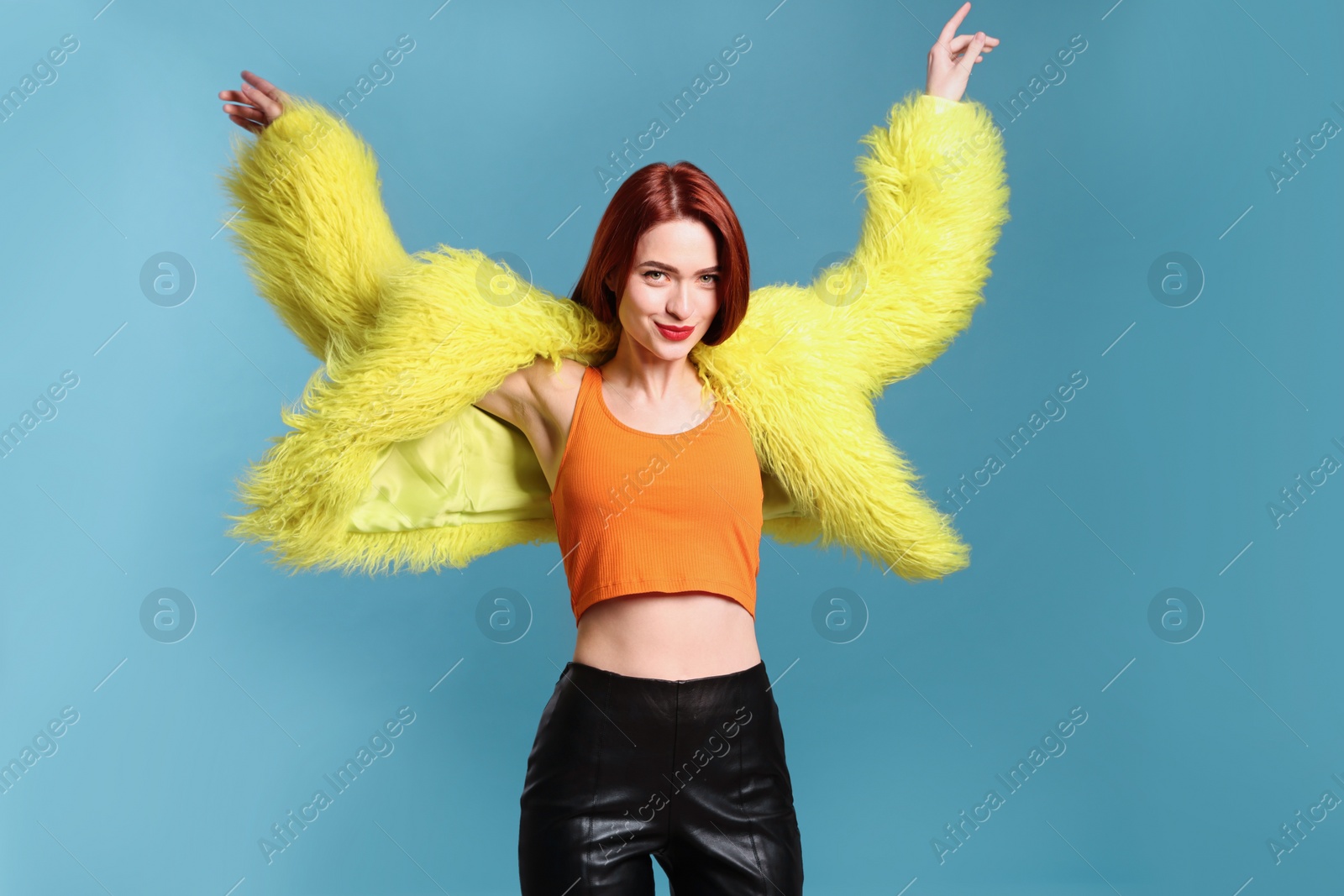 Photo of Stylish woman with red dyed hair on light blue background