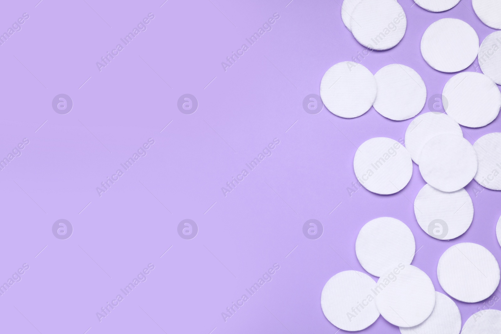 Photo of Many cotton pads on lilac background, flat lay. Space for text