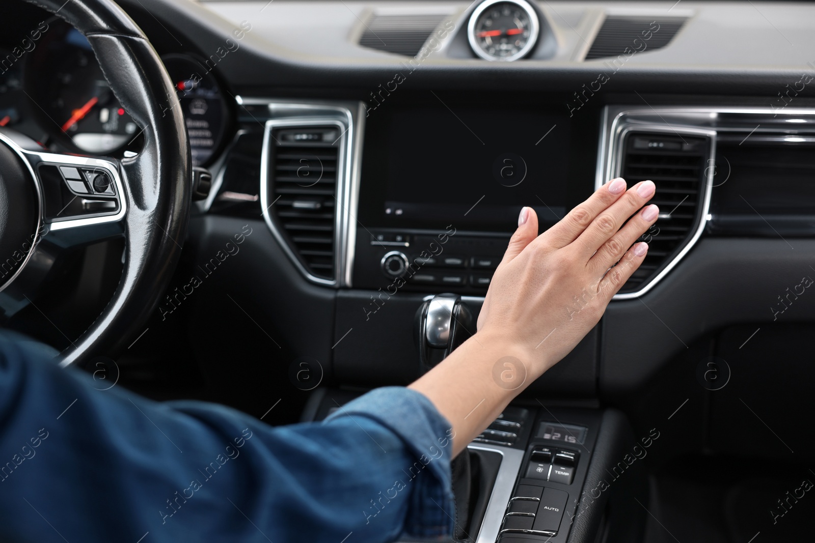 Photo of Woman checking air conditioner in her car, closeup