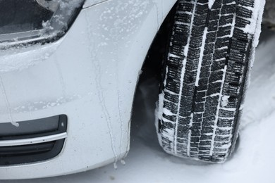 Car with winter tires on snowy road, closeup