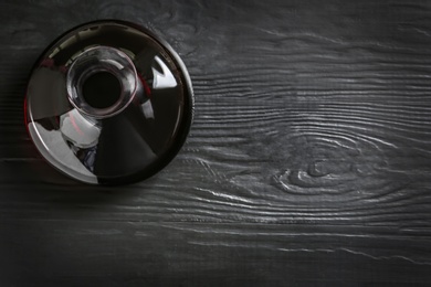 Photo of Decanter with red wine on wooden background, top view