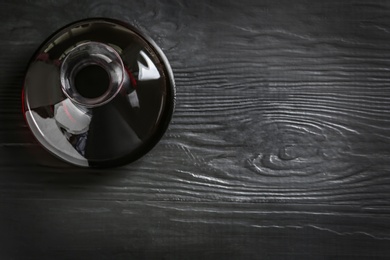 Decanter with red wine on wooden background, top view