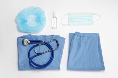 Photo of Flat lay composition with medical uniform and stethoscope on white background