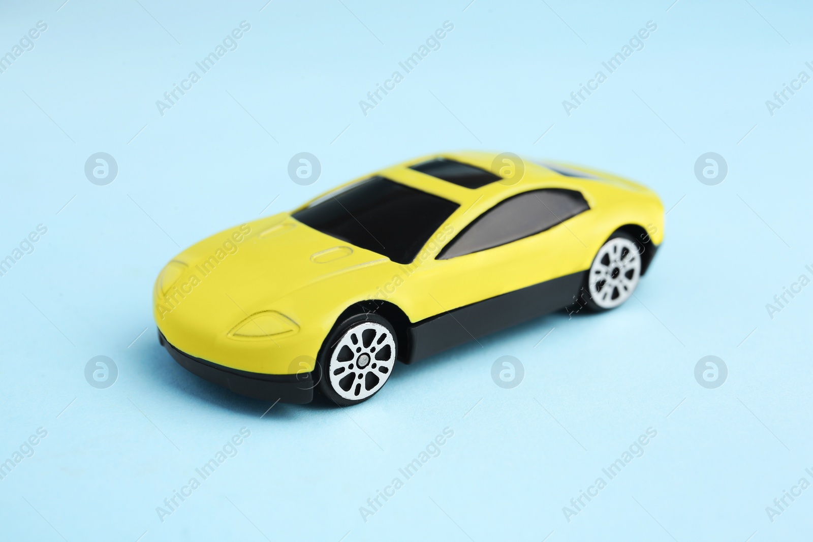 Photo of One yellow car on light blue background. Children`s toy
