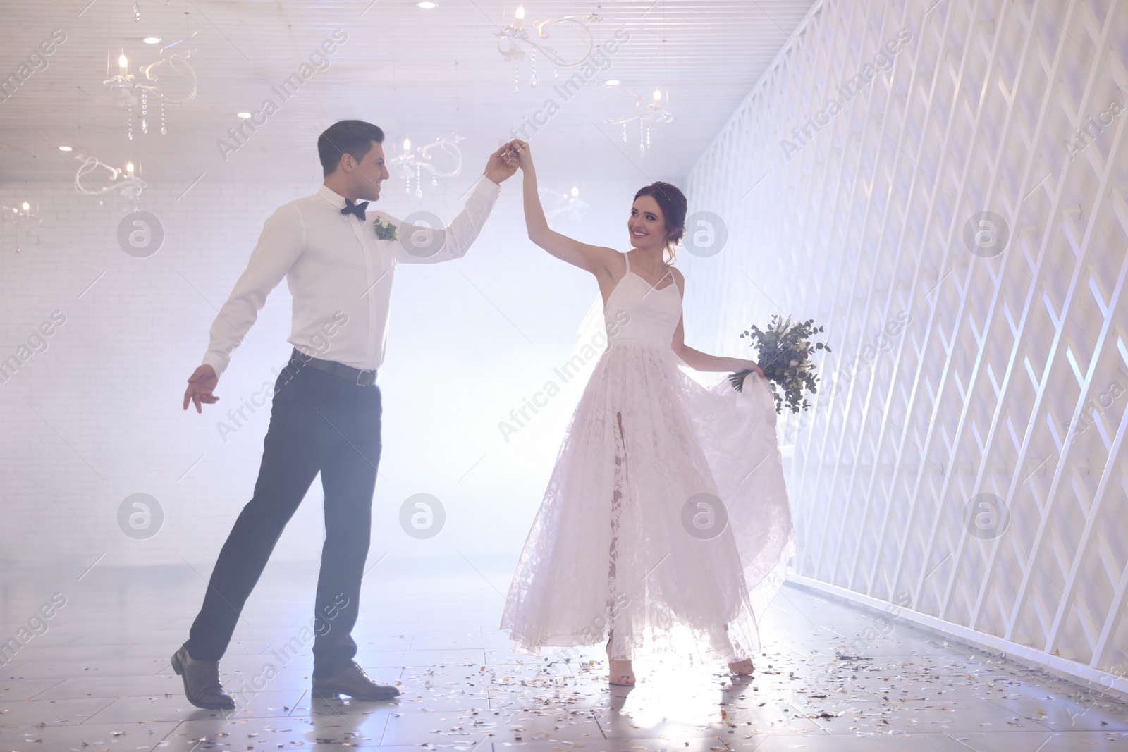 Photo of Happy newlywed couple dancing together in festive hall