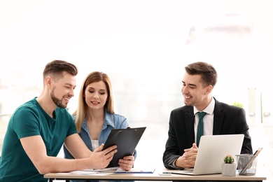 Photo of Young couple meeting with consultant in office