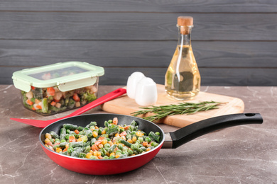 Photo of Tasty frozen vegetable mix on brown marble table