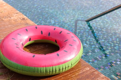 Photo of Inflatable ring on wooden deck near swimming pool. Luxury resort