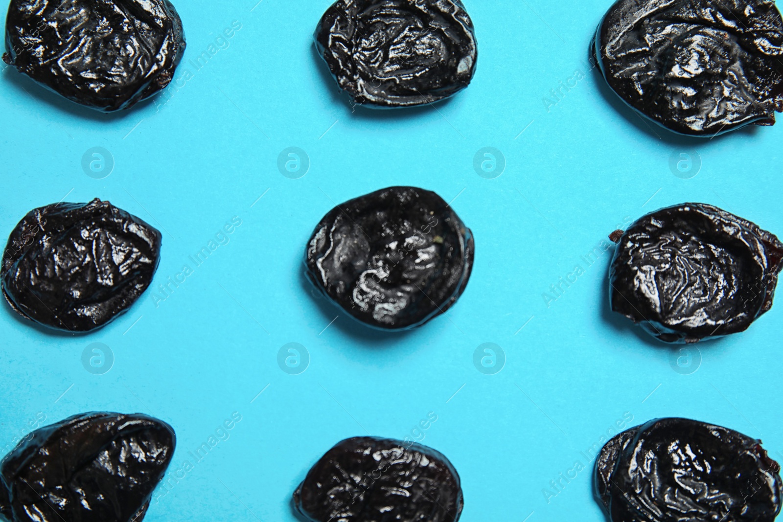 Photo of Flat lay composition with tasty prunes on color background. Dried fruit as healthy snack